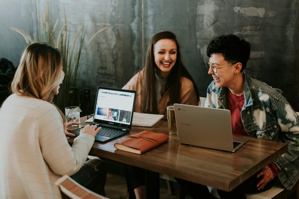 Group Study three people sitting in front of table laughing together